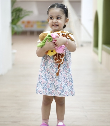 Smiling child holding stuffed animals